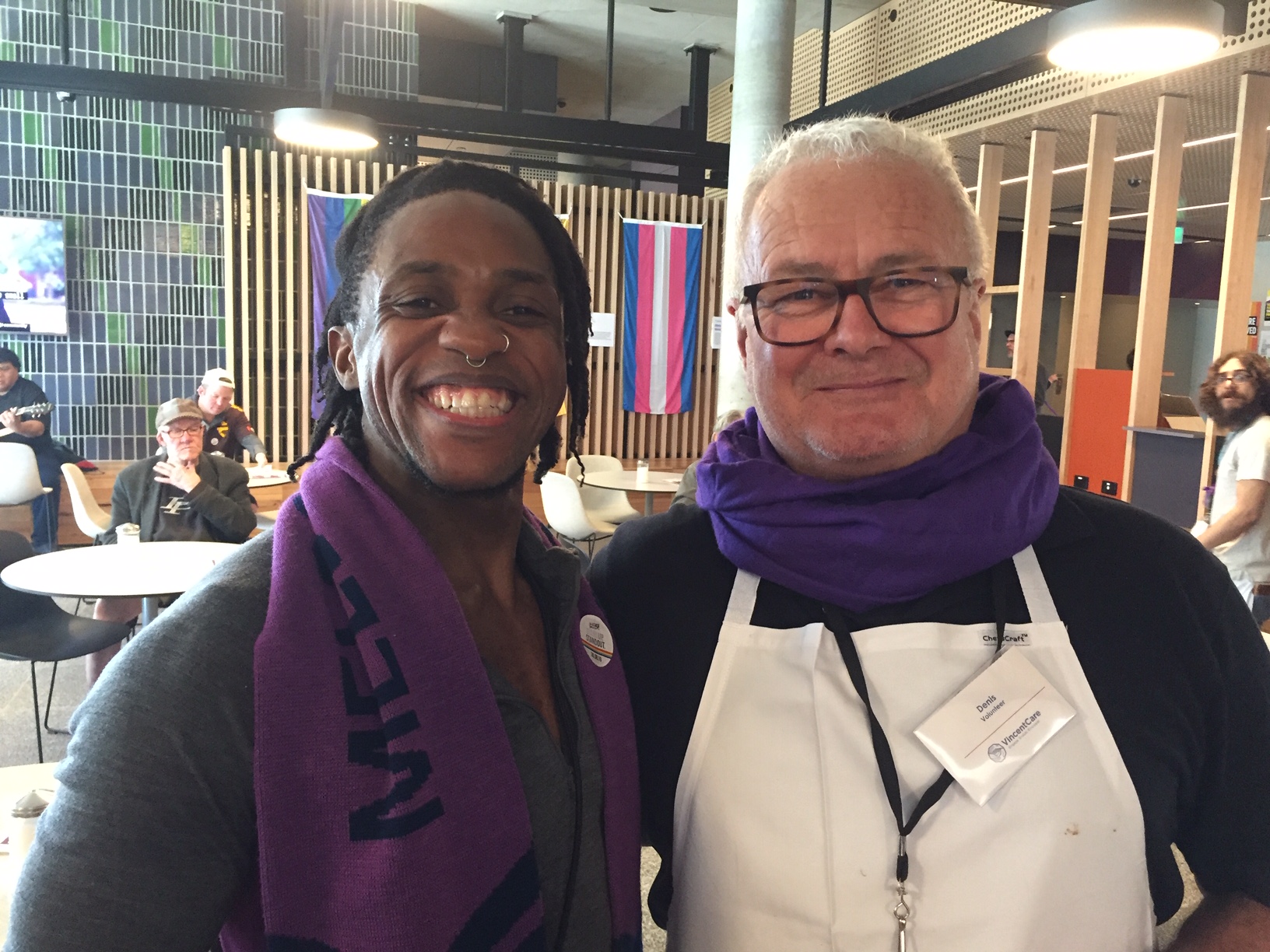 Two men wearing purple scarves