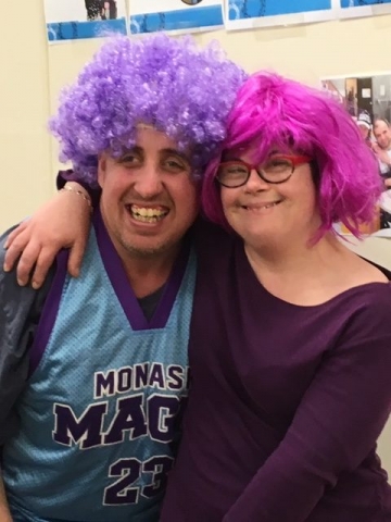 Two young people wearing colourful wigs.